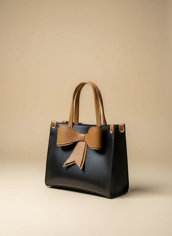 Black handbag with a large beige bow on a dark background